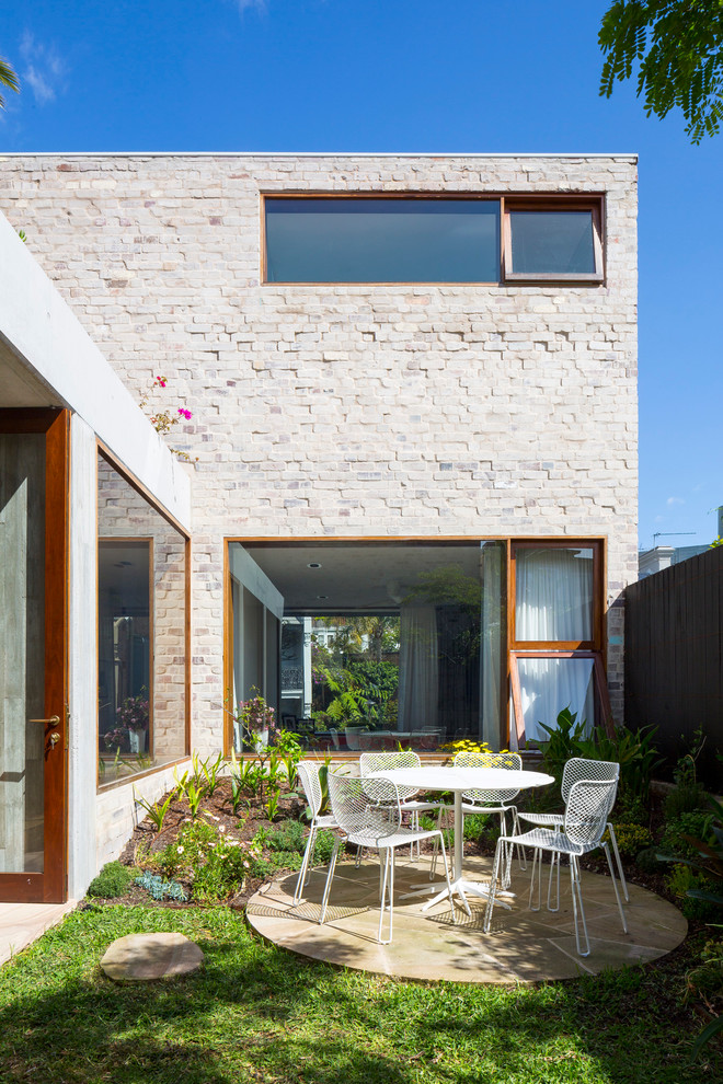 Photo of a mid-sized contemporary courtyard patio in Sydney with natural stone pavers.
