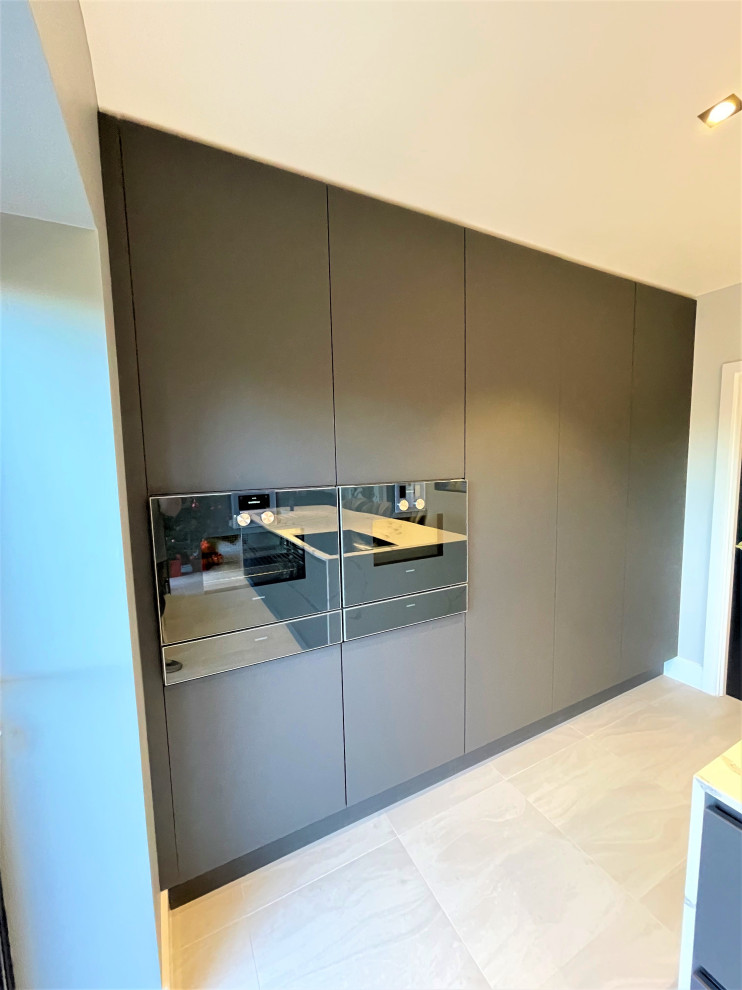 Photo of a medium sized contemporary grey and white single-wall open plan kitchen in Other with a single-bowl sink, flat-panel cabinets, medium wood cabinets, vinyl flooring, an island, grey floors and feature lighting.