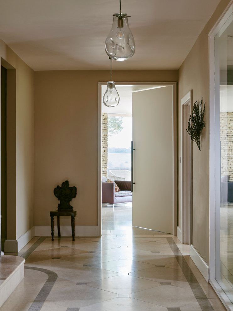 Photo of a large transitional hallway in Wiltshire with beige walls, limestone floors and multi-coloured floor.