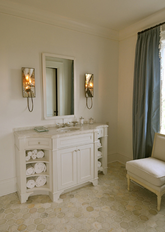 This is an example of a mid-sized beach style 3/4 bathroom in Charleston with recessed-panel cabinets, white cabinets, marble benchtops, white tile, ceramic tile, white walls and mosaic tile floors.