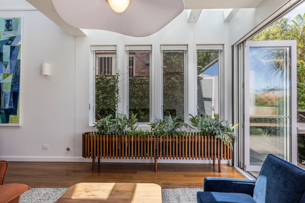 Ispirazione per una veranda moderna di medie dimensioni con pavimento in legno massello medio e pavimento marrone