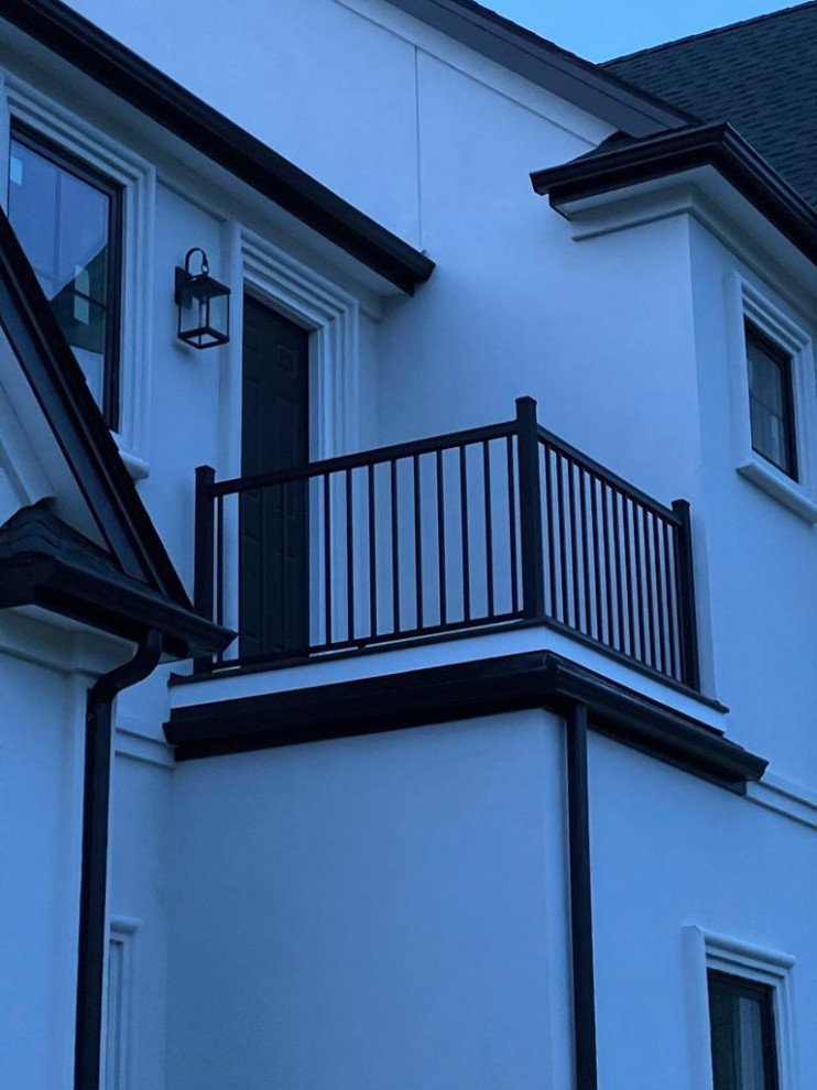 Cette image montre une terrasse arrière et au premier étage minimaliste avec un garde-corps en matériaux mixtes.