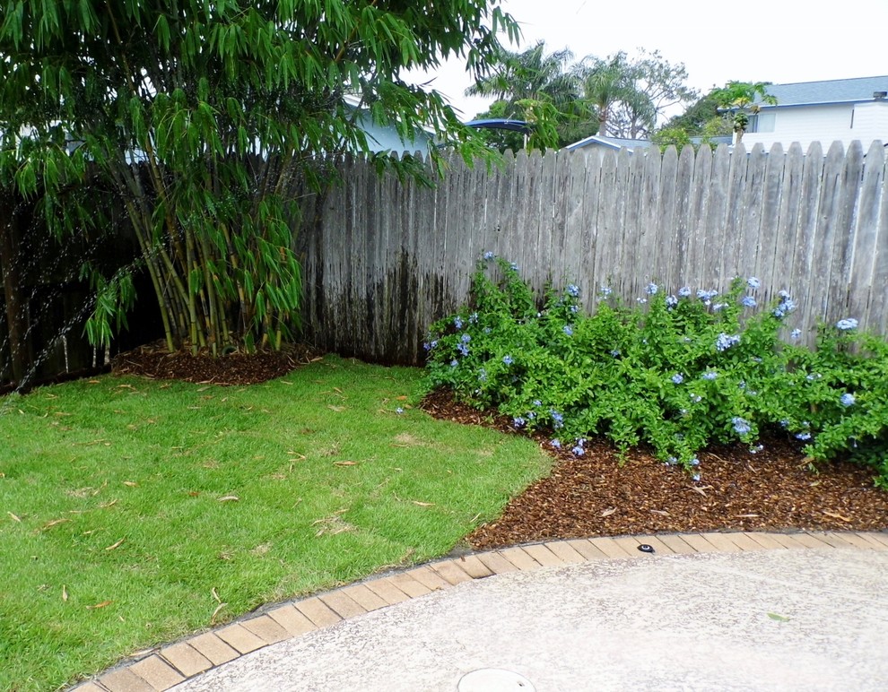 Design ideas for a mid-sized tropical backyard partial sun garden in Tampa.