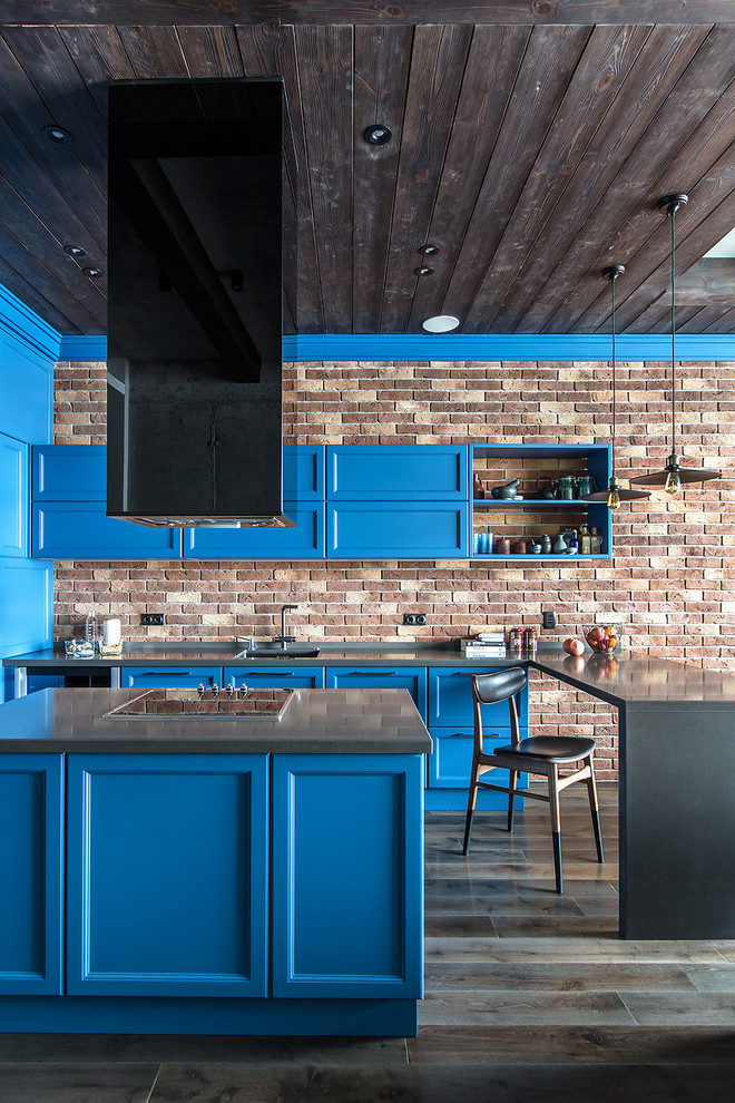 This is an example of an industrial u-shaped open plan kitchen in Moscow with quartzite benchtops, with island, an undermount sink, recessed-panel cabinets, blue cabinets, brick splashback, dark hardwood floors, grey benchtop and brown splashback.