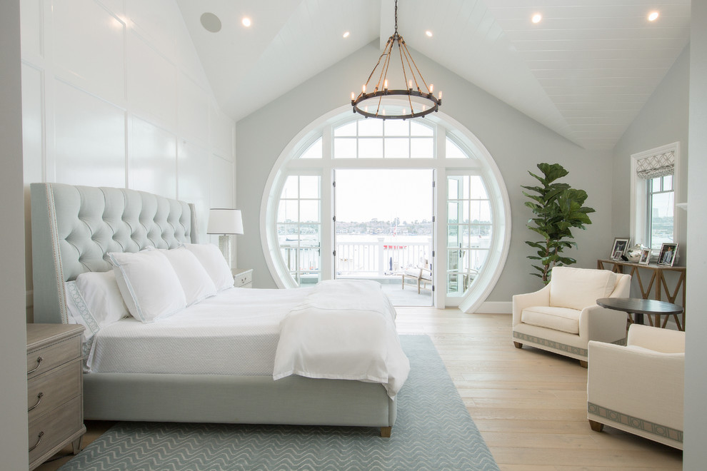 Inspiration for a beach style bedroom in Orange County with blue walls, light hardwood floors and beige floor.