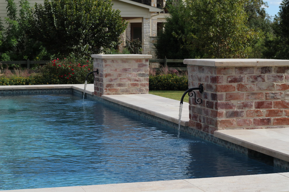Design ideas for a traditional pool in Houston with a water feature.