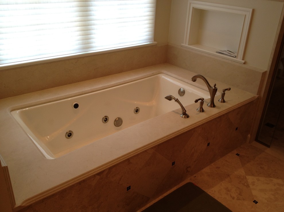 Design ideas for a bathroom in St Louis with a japanese tub, beige walls, ceramic floors, a vessel sink, shaker cabinets, medium wood cabinets and marble benchtops.