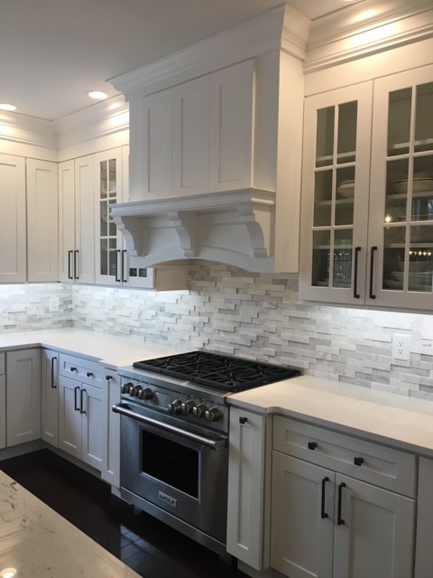 Inspiration for a large transitional u-shaped dark wood floor and brown floor eat-in kitchen remodel with an undermount sink, recessed-panel cabinets, white cabinets, white backsplash, stone tile backsplash, stainless steel appliances, an island, white countertops and quartzite countertops