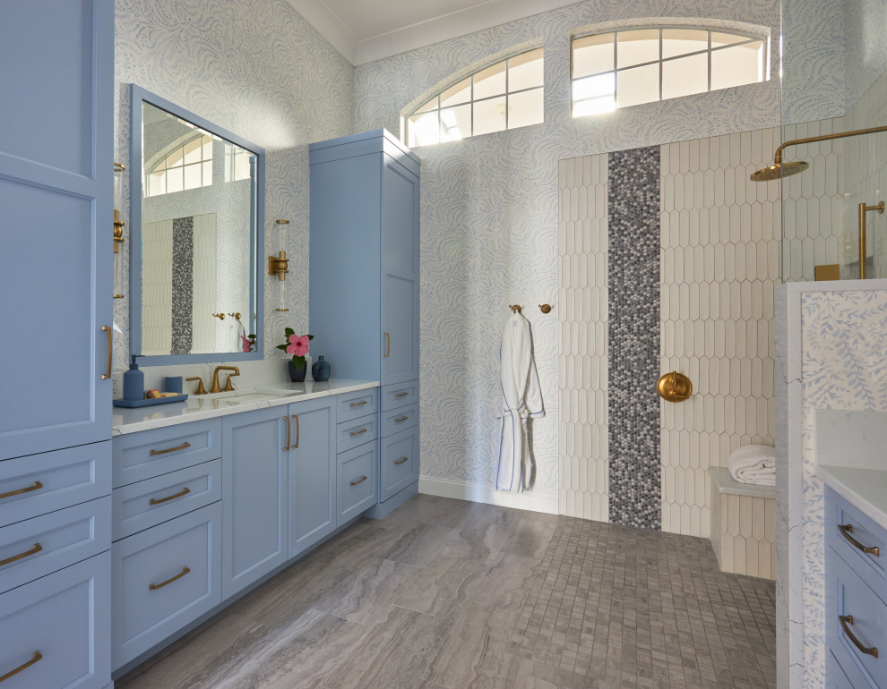 На фото: большая главная ванная комната в стиле неоклассика (современная классика) с фасадами в стиле шейкер, синими фасадами, душем без бортиков, раздельным унитазом, белой плиткой, керамической плиткой, синими стенами, полом из керамогранита, врезной раковиной, столешницей из искусственного кварца, серым полом, открытым душем, белой столешницей, нишей, тумбой под две раковины, встроенной тумбой и обоями на стенах с