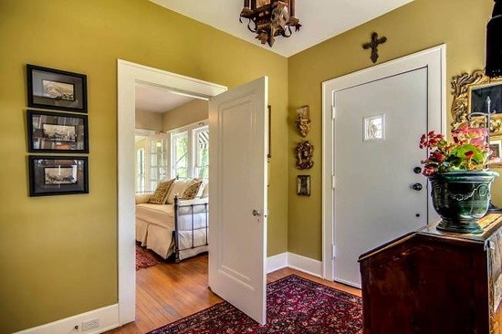 Example of a huge eclectic medium tone wood floor foyer design in Austin with green walls and a red front door