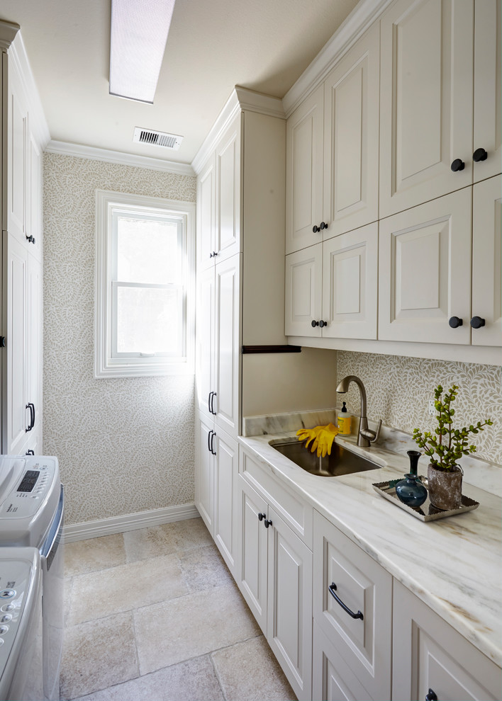 Photo of a traditional galley dedicated laundry room in Houston with an undermount sink, raised-panel cabinets, white cabinets, a side-by-side washer and dryer, white benchtop and grey walls.
