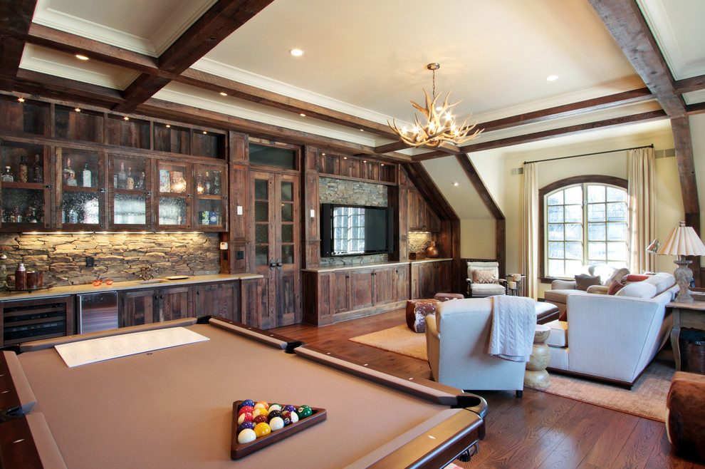 Photo of a country family room in New York with a game room, beige walls, medium hardwood floors and a wall-mounted tv.