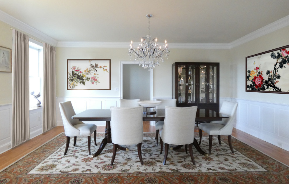 This is an example of a mid-sized traditional separate dining room in Philadelphia with beige walls, light hardwood floors and decorative wall panelling.