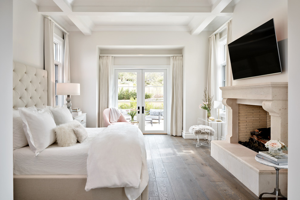 Large tuscan master dark wood floor and coffered ceiling bedroom photo in Phoenix with white walls, a standard fireplace and a stone fireplace