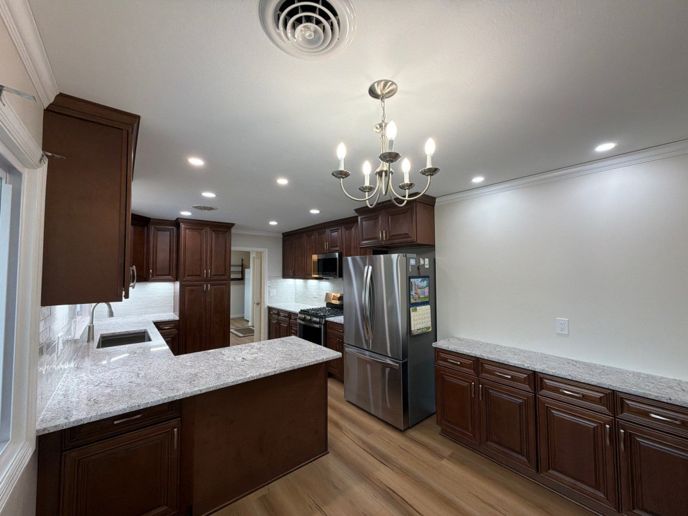 USCD cabinetry accompanied granite countertops, porcelain tile backsplash and Ca