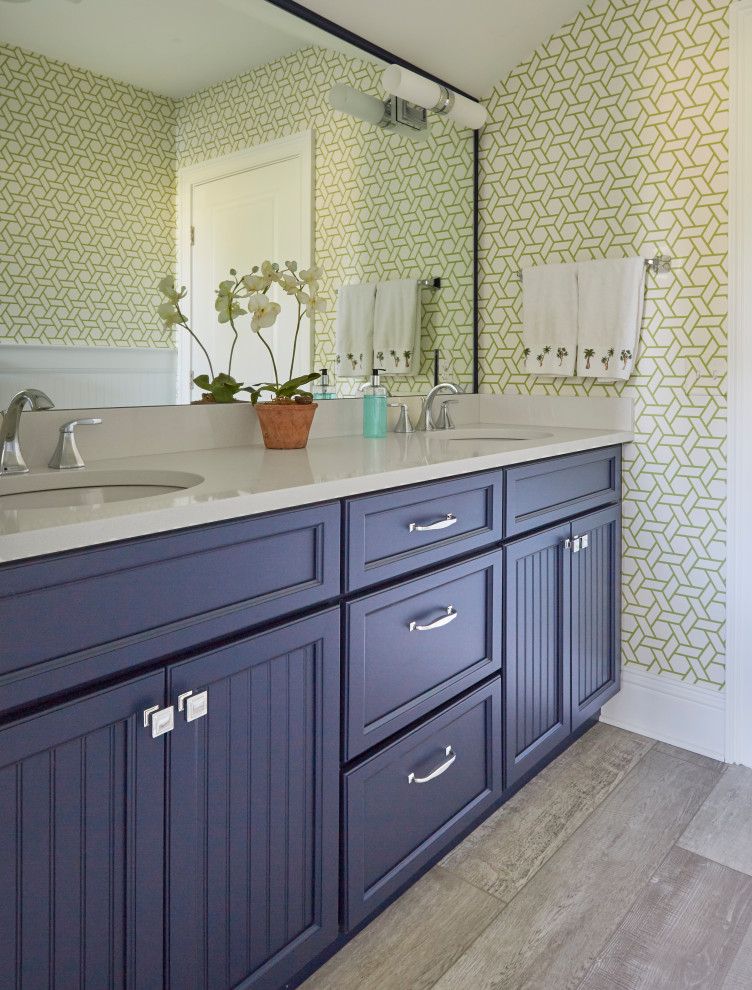 Photo of a mid-sized traditional kids bathroom in Jacksonville with recessed-panel cabinets, blue cabinets, an alcove shower, a two-piece toilet, white tile, porcelain tile, green walls, porcelain floors, an undermount sink, engineered quartz benchtops, beige floor, a shower curtain and white benchtops.