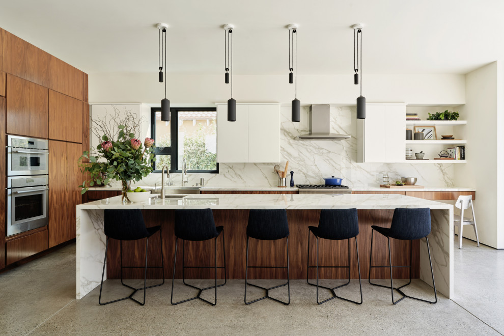 Example of a mid-sized trendy l-shaped concrete floor and gray floor open concept kitchen design in Los Angeles with a farmhouse sink, flat-panel cabinets, dark wood cabinets, quartz countertops, white backsplash, quartz backsplash, paneled appliances, an island and white countertops