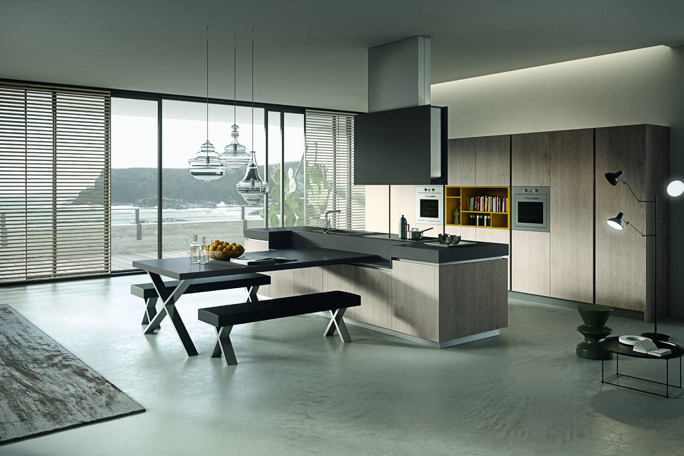 Photo of a mid-sized modern galley eat-in kitchen in Vancouver with a single-bowl sink, flat-panel cabinets, light wood cabinets, solid surface benchtops, stainless steel appliances, concrete floors, with island and grey floor.