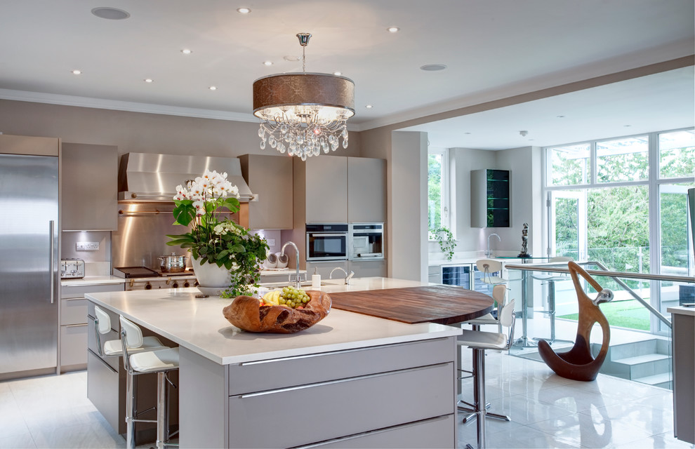 Inspiration for a transitional galley kitchen in Belfast with an undermount sink, flat-panel cabinets, grey cabinets, metallic splashback, stainless steel appliances and with island.