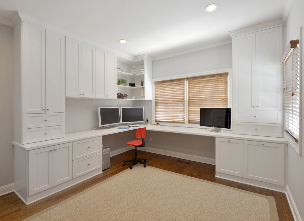 Inspiration for a large contemporary home office in New York with white walls, medium hardwood floors and a built-in desk.