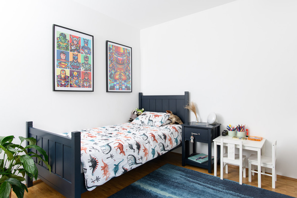 Diseño de dormitorio infantil de 1 a 3 años moderno de tamaño medio con paredes blancas, suelo de madera en tonos medios y suelo marrón