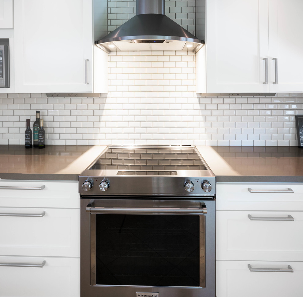 Inspiration for a large transitional travertine floor and beige floor eat-in kitchen remodel in Phoenix with an undermount sink, shaker cabinets, white cabinets, quartz countertops, beige backsplash, subway tile backsplash, stainless steel appliances and an island