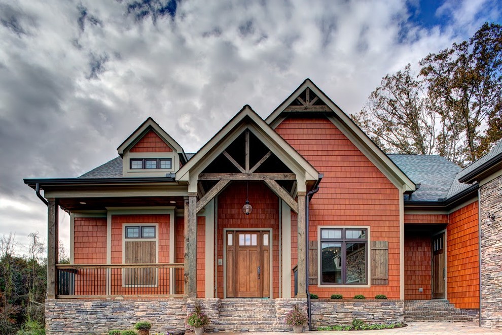 Mid-sized country one-storey orange house exterior in Other with wood siding, a gable roof and a shingle roof.