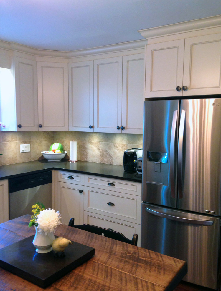 Example of a mid-sized mountain style l-shaped medium tone wood floor and brown floor enclosed kitchen design in Ottawa with a farmhouse sink, recessed-panel cabinets, beige cabinets, quartz countertops, beige backsplash, ceramic backsplash, stainless steel appliances, an island and brown countertops