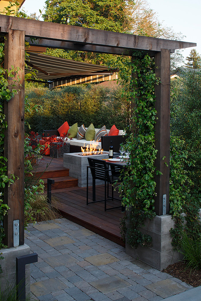Contemporary backyard deck in San Francisco with a fire feature and a pergola.
