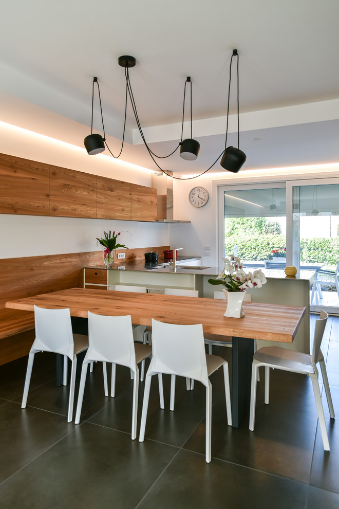 Mid-sized contemporary kitchen/dining combo in Other with white walls, ceramic floors, no fireplace and black floor.