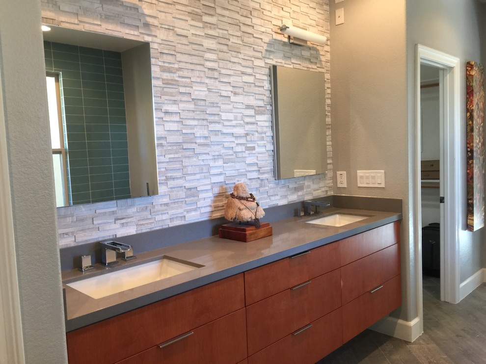 Large arts and crafts master bathroom in San Diego with flat-panel cabinets, medium wood cabinets, a freestanding tub, an alcove shower, white tile, stone tile, grey walls, medium hardwood floors, an undermount sink, solid surface benchtops, brown floor and a hinged shower door.