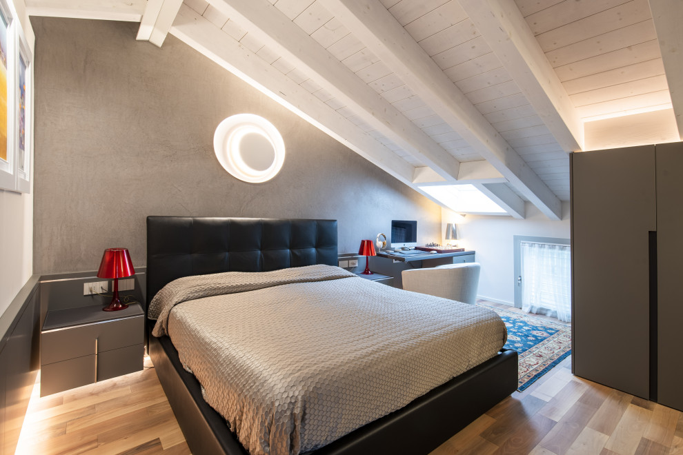 На фото: хозяйская спальня среднего размера на мансарде в стиле модернизм с серыми стенами, деревянным полом, коричневым полом, балками на потолке и панелями на стенах с