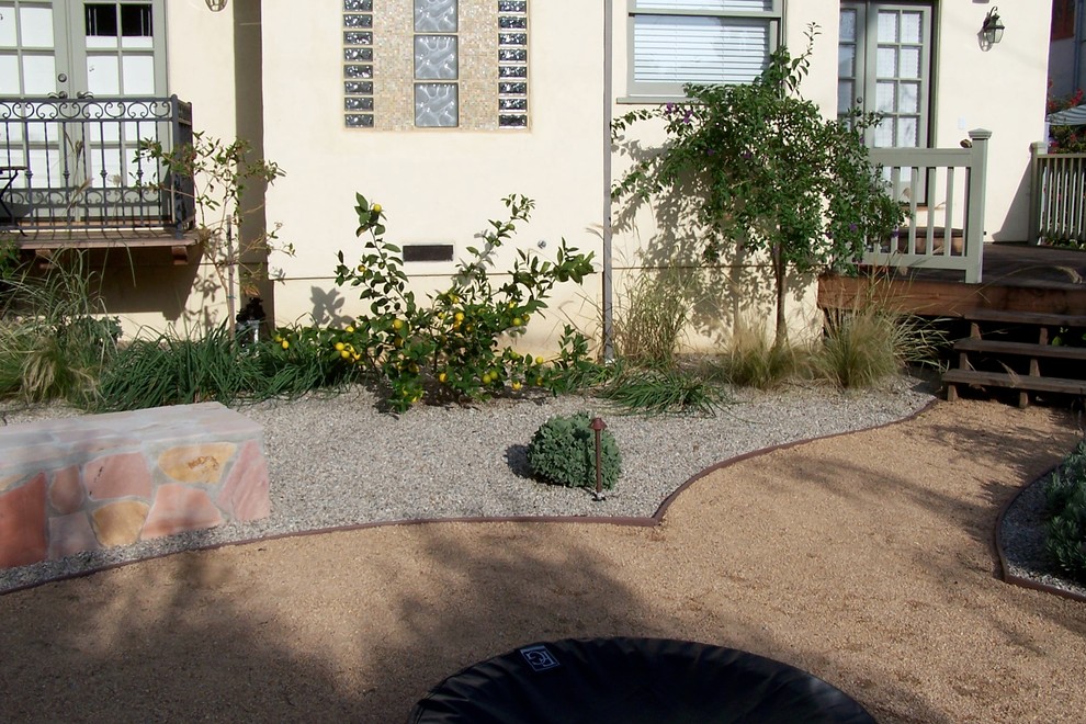 This is an example of a mid-sized mediterranean backyard patio in Los Angeles with a fire feature, gravel and no cover.