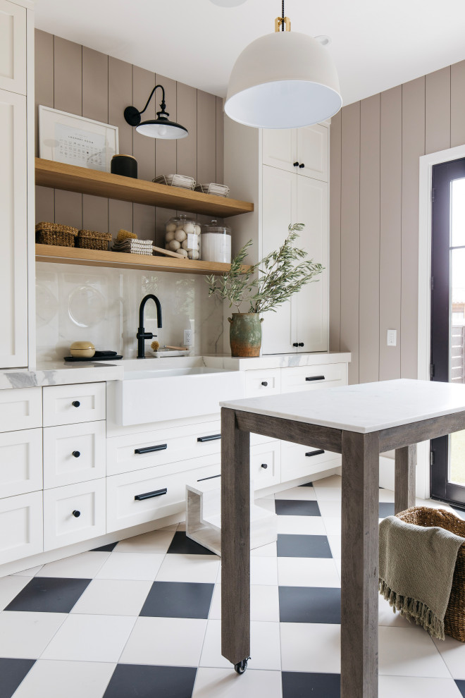 Design ideas for a large rural galley utility room in Phoenix with a belfast sink, recessed-panel cabinets, white cabinets, marble worktops, grey splashback, marble splashback, white walls, ceramic flooring, a stacked washer and dryer, black floors, white worktops, tongue and groove walls and feature lighting.