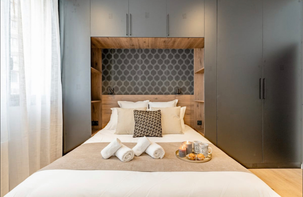 Kleines Modernes Hauptschlafzimmer ohne Kamin mit schwarzer Wandfarbe, hellem Holzboden, beigem Boden und Tapetenwänden in Lyon