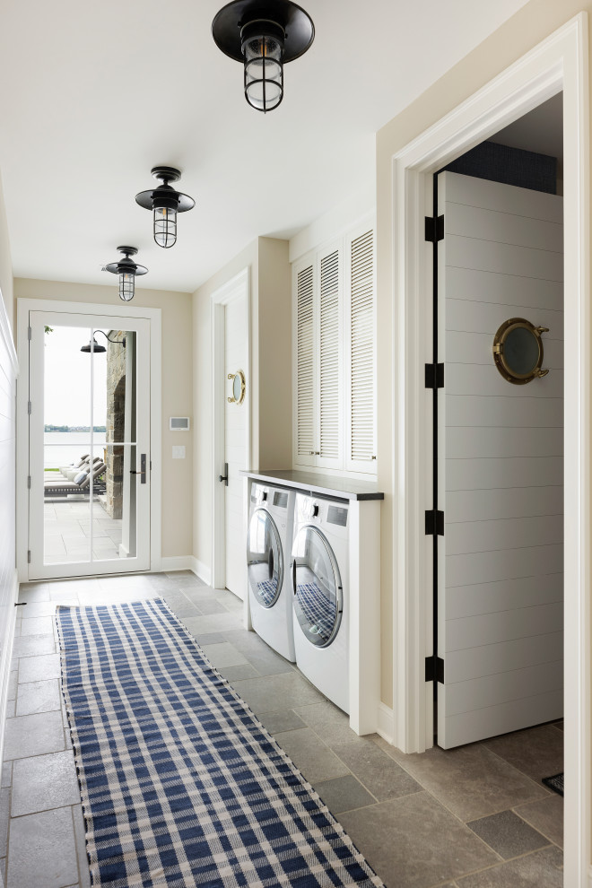 Design ideas for a mid-sized beach style laundry room in Minneapolis with limestone floors.
