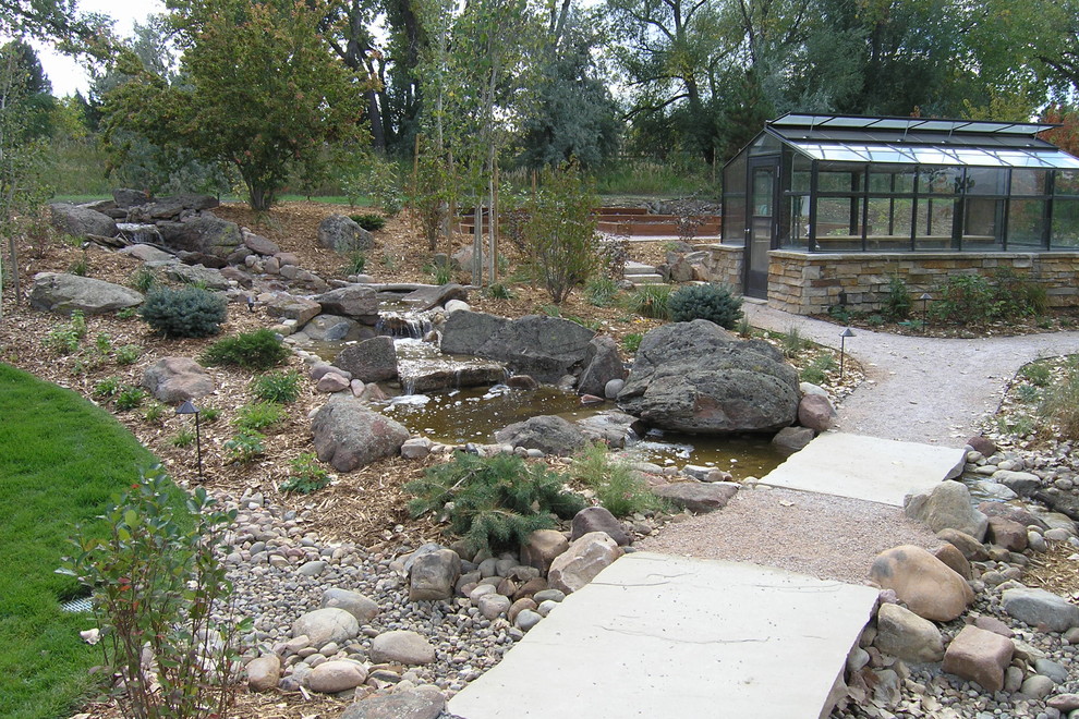 Photo of a country backyard full sun garden for spring in Denver with a water feature and gravel.