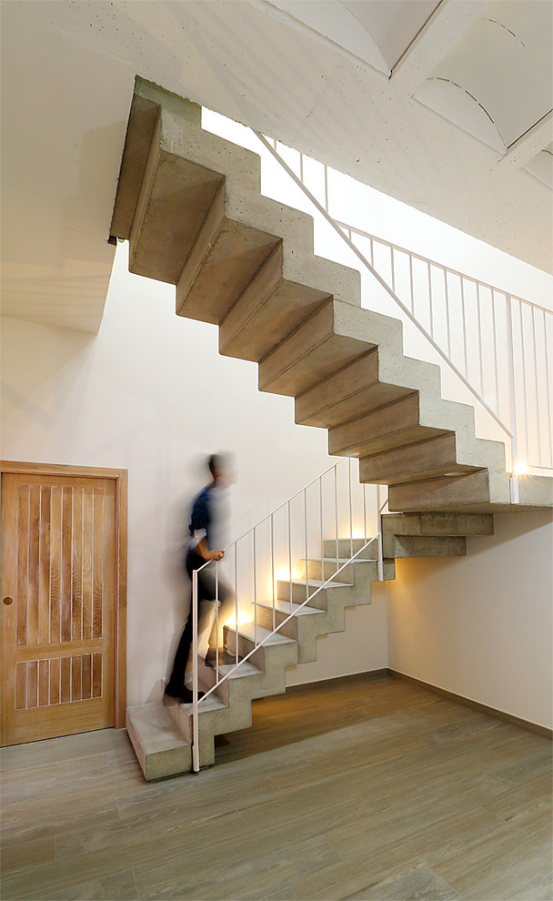 Inspiration for a mediterranean concrete l-shaped staircase in Valencia with concrete risers and metal railing.