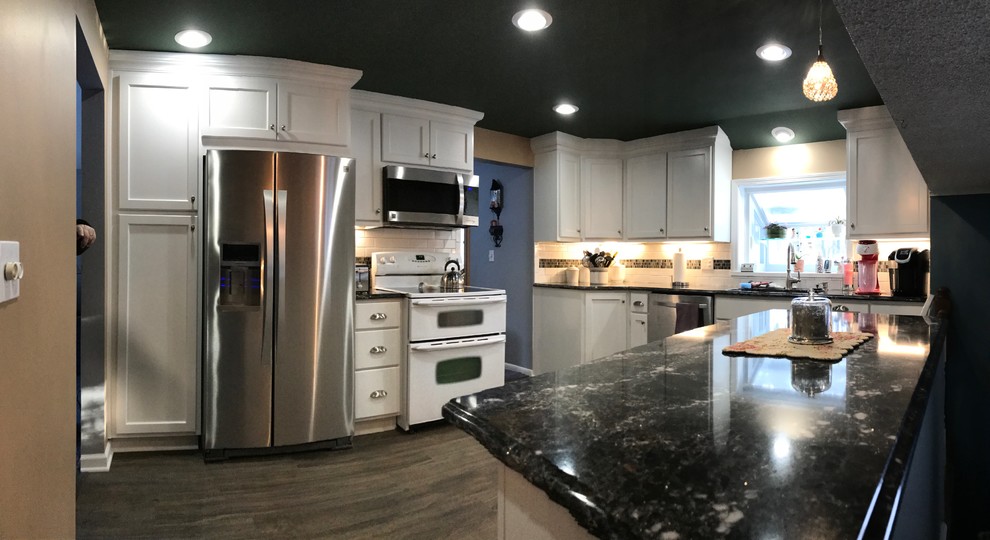 Example of a mid-sized transitional u-shaped medium tone wood floor eat-in kitchen design in New York with a double-bowl sink, shaker cabinets, white cabinets, granite countertops, white backsplash, subway tile backsplash and stainless steel appliances