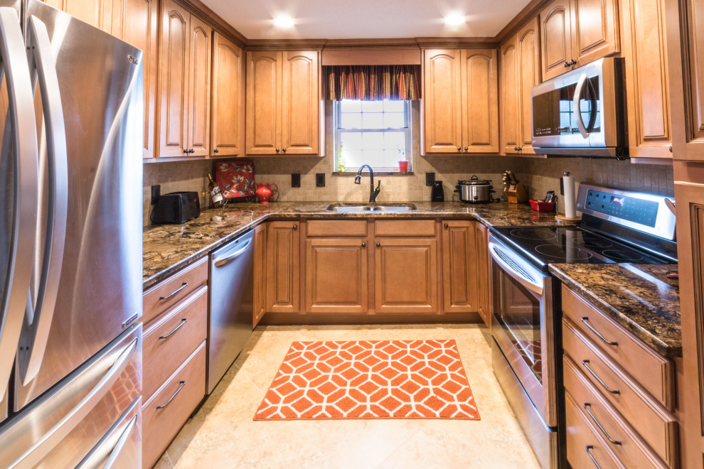 Mid-sized u-shaped cement tile floor and beige floor eat-in kitchen photo with an undermount sink, raised-panel cabinets, medium tone wood cabinets, granite countertops, stainless steel appliances, no island and brown countertops
