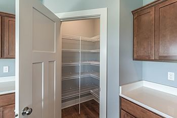 Eat-in kitchen - mid-sized transitional l-shaped medium tone wood floor eat-in kitchen idea with an undermount sink, recessed-panel cabinets, medium tone wood cabinets, quartz countertops, black appliances and an island