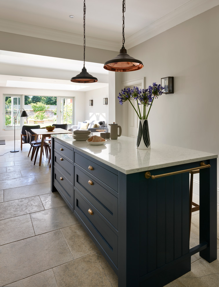 Photo of a mid-sized transitional kitchen in Sussex with a farmhouse sink, white splashback, subway tile splashback, stainless steel appliances and with island.