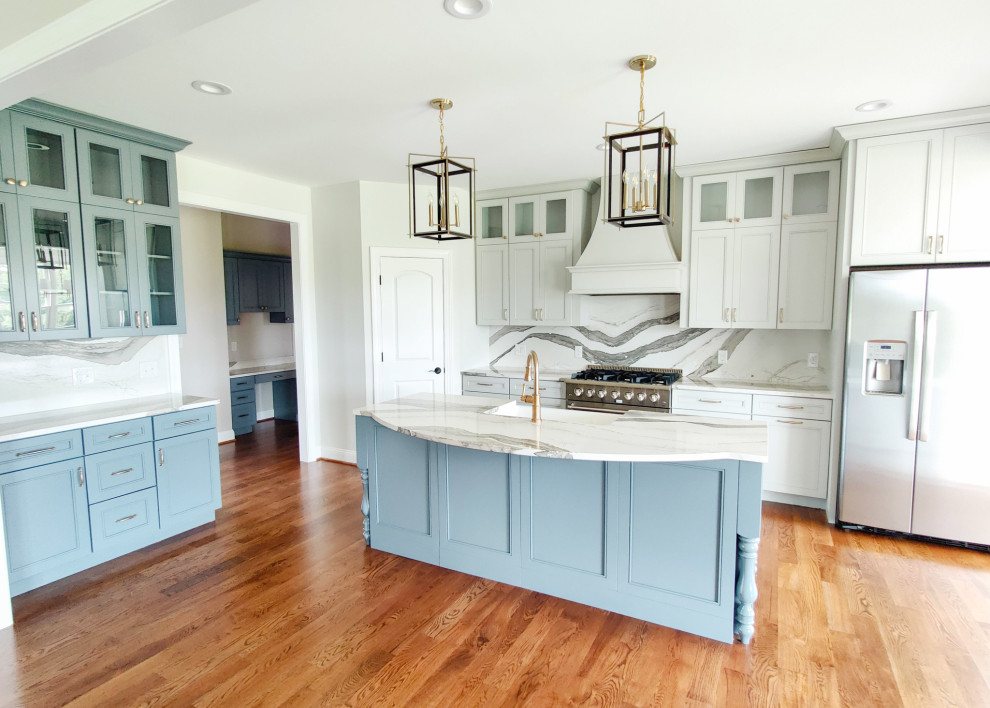 Transitional l-shaped medium tone wood floor and brown floor open concept kitchen photo with a farmhouse sink, recessed-panel cabinets, gray cabinets, quartz countertops, multicolored backsplash, quartz backsplash, stainless steel appliances, an island and multicolored countertops