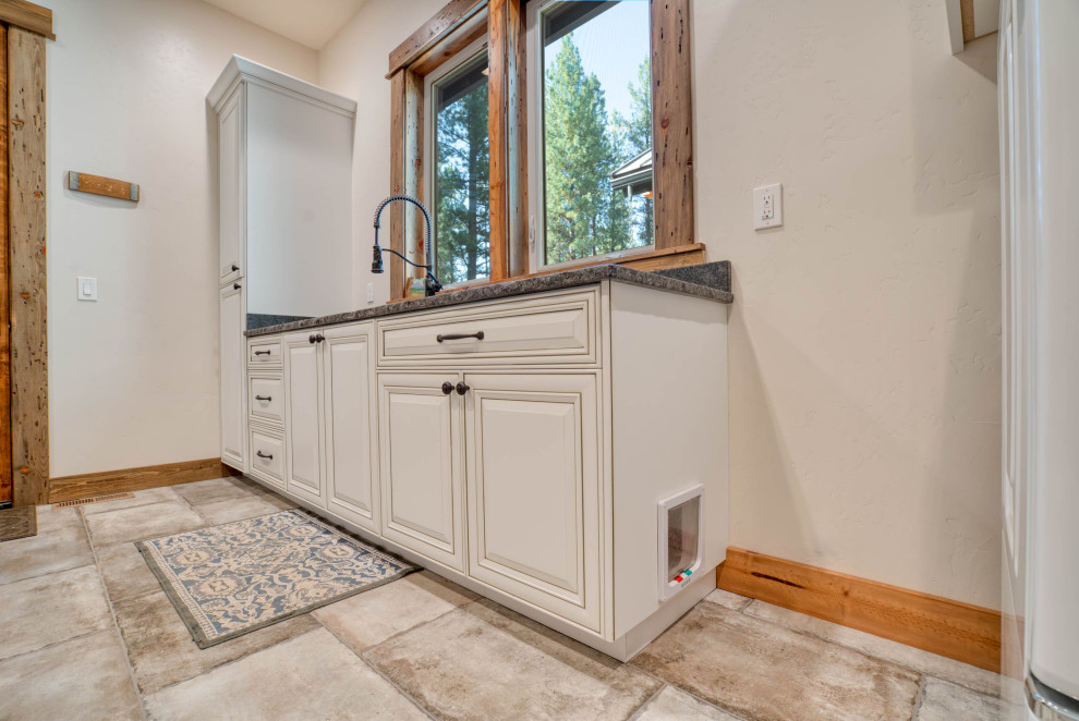 Large country galley ceramic tile, beige floor and exposed beam dedicated laundry room photo in Other with an undermount sink, raised-panel cabinets, white cabinets, granite countertops, gray backsplash, granite backsplash, beige walls, a side-by-side washer/dryer and gray countertops