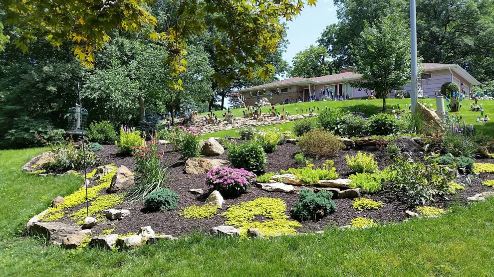 This is an example of a small eclectic front yard full sun xeriscape for spring in Kansas City with mulch and a container garden.