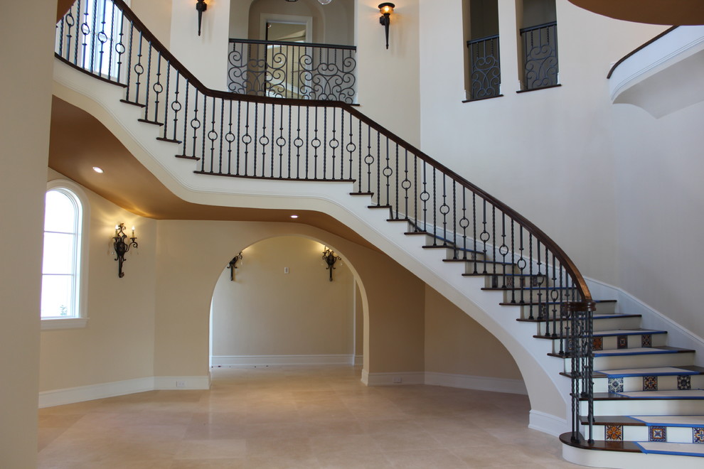 Large mediterranean wood curved staircase in Other with tile risers and mixed railing.