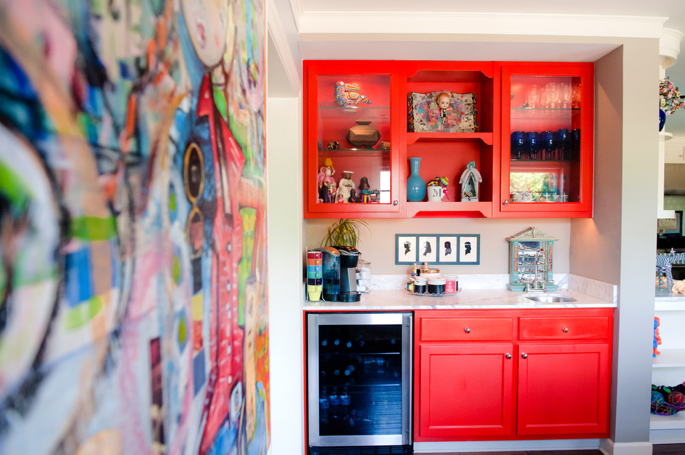 Inspiration for a small eclectic home bar in Phoenix with red cabinets.