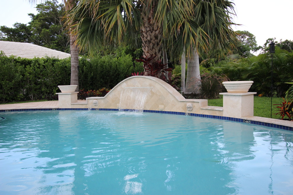 Mid-sized transitional backyard brick and custom-shaped natural pool fountain photo in Miami
