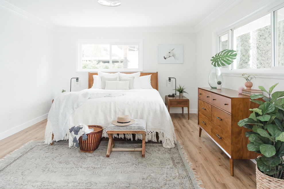 Country master bedroom in San Diego with white walls, light hardwood floors and beige floor.