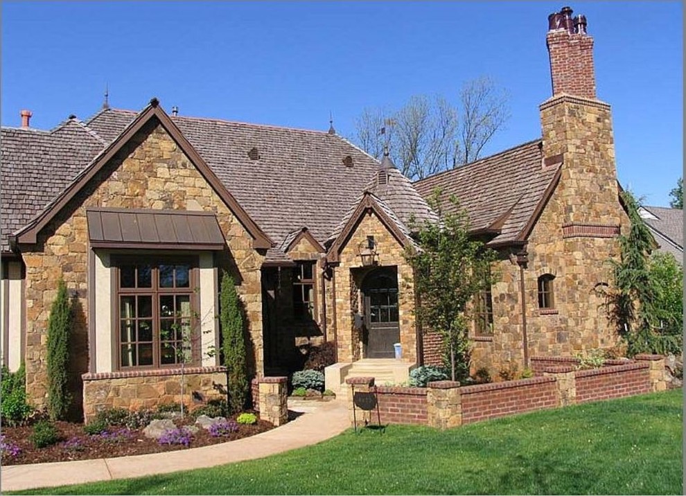 Inspiration for a mid-sized traditional two-storey brown house exterior in Other with stone veneer, a gable roof and a shingle roof.